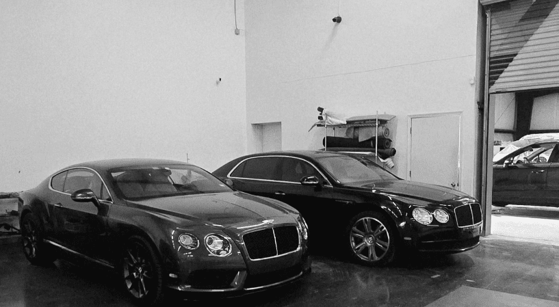 Two Bentley vehicles inside luxury Houston auto body facility