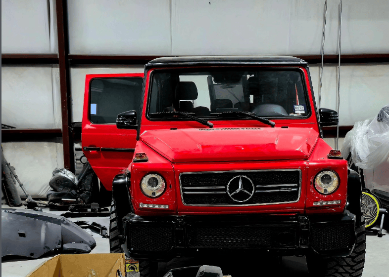 Red Mercedes G-Wagon inside Houston collision repair facility